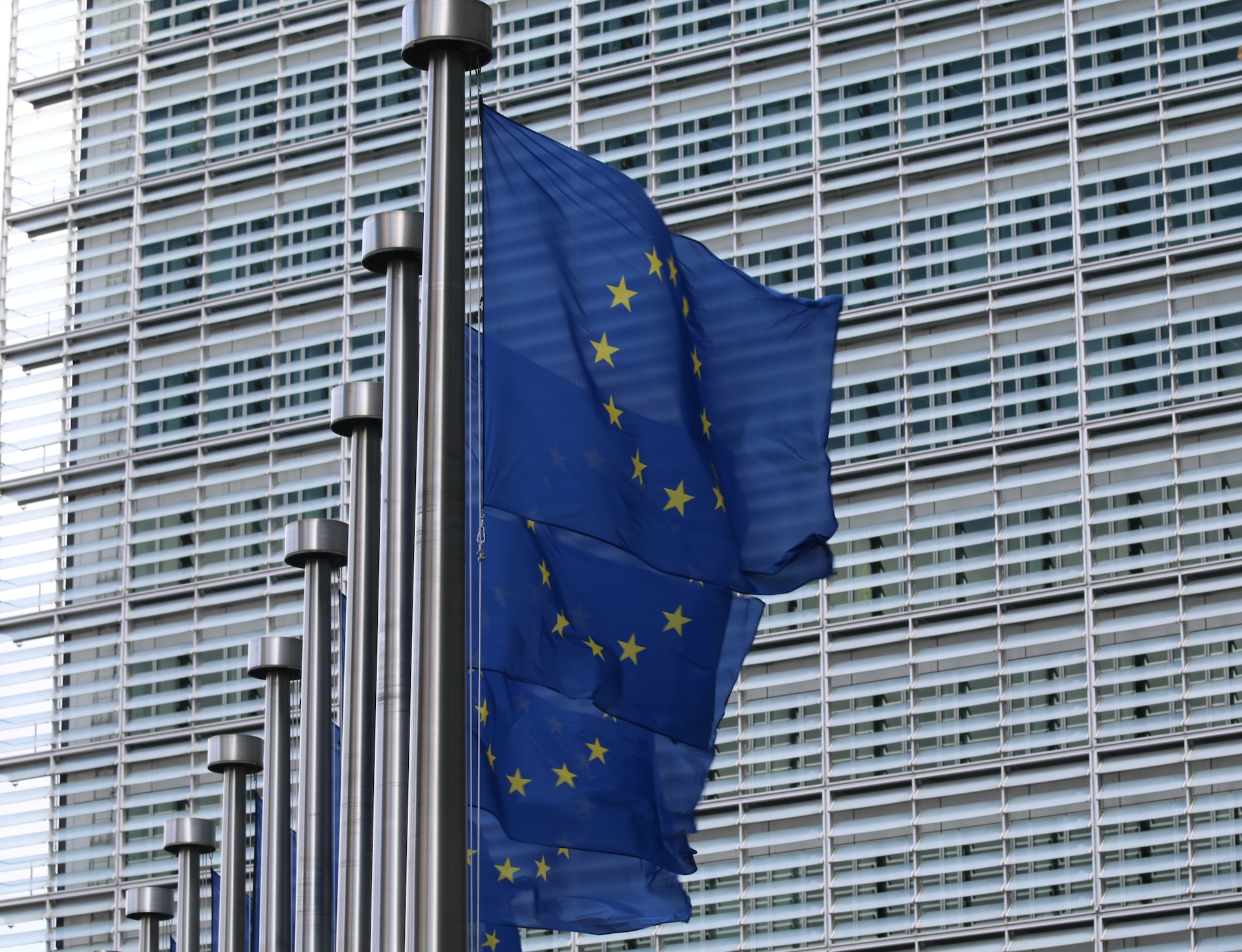EU-Flaggen am Fahnenmast vor Bürokomplex