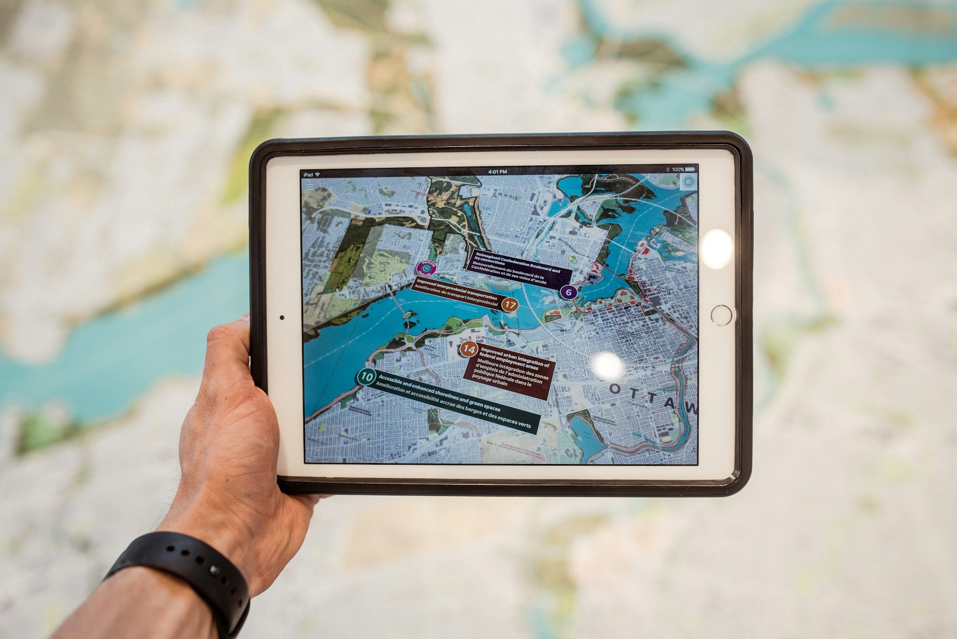 Blogbeitrag_XR_Manager_AR Ein Tablet, dass über eine Landkarte gehalten wird. Per Augmentend Reality zeigt der Bildschirm des Tablets virtuell ergänzende Informationen an.