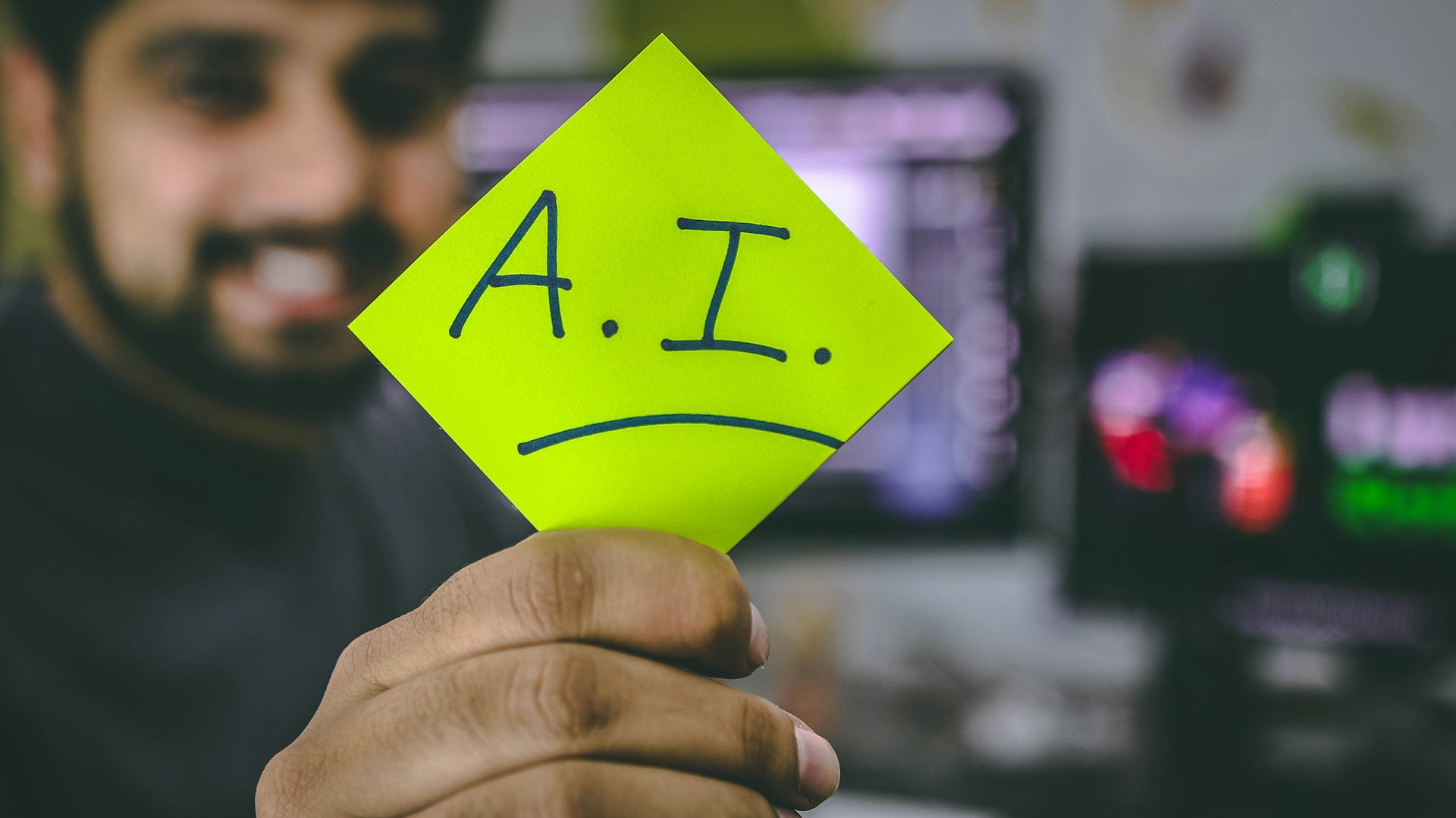 Ein Mann, der einen Zettel hochhält, auf dem das Wort A.I. geschrieben ist. Englische Abkürzung für KI (Künstliche Intelligenz).
