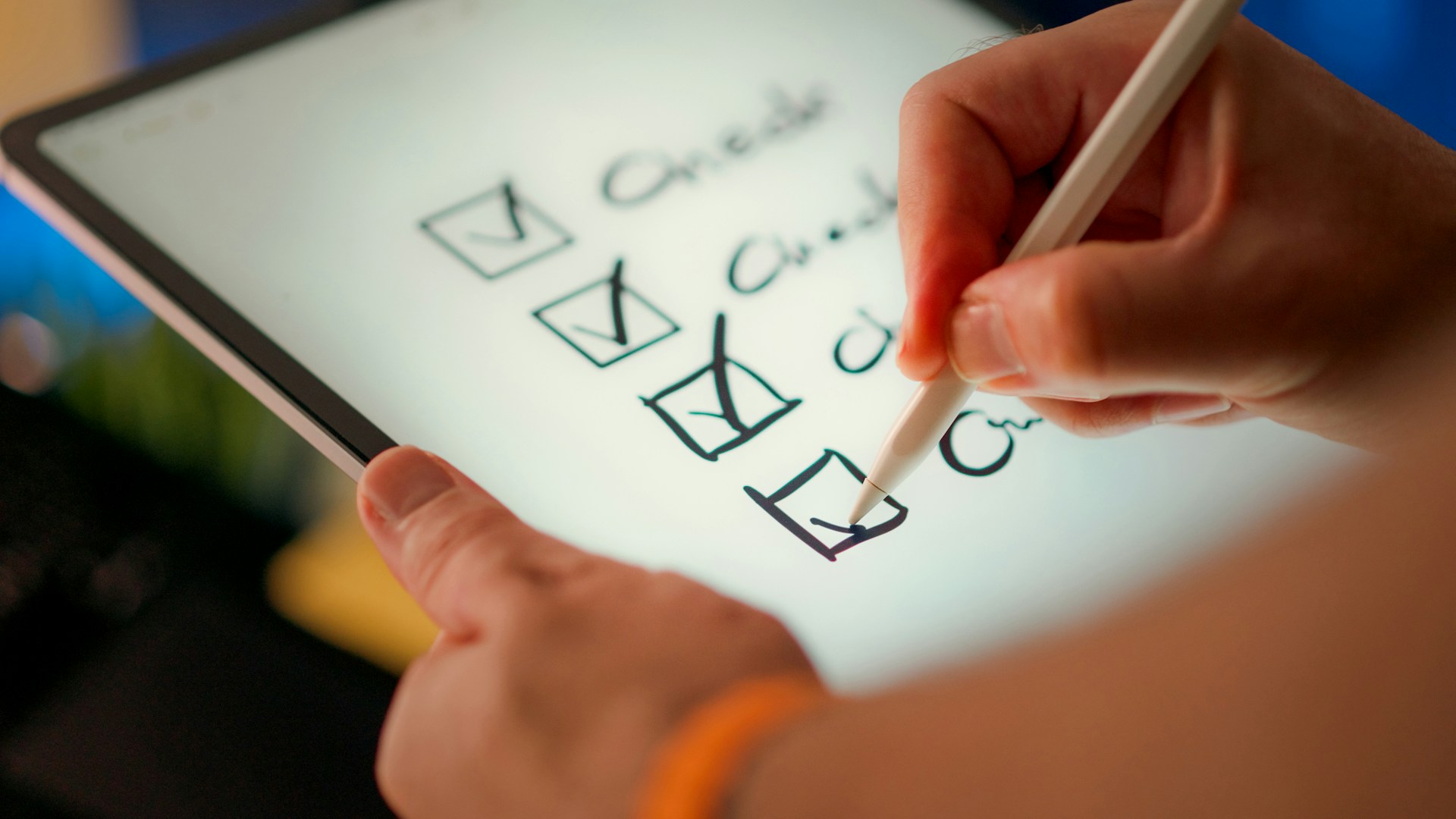 Eine Tablet, auf dem eine Checkliste aufgerufen ist. Eine Person kreuzt Kästchen nacheinander ab.
